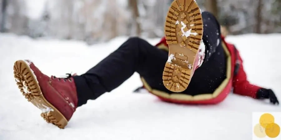 Person in a red winter coat falling backward on a snowy path
